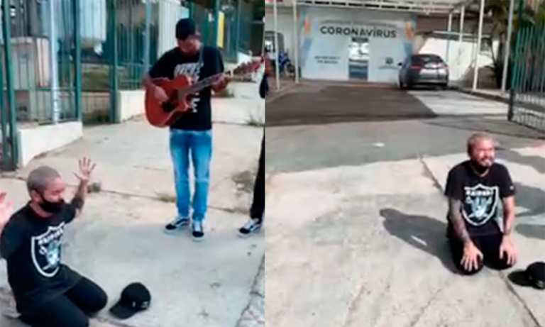 Yudi ajoelha e faz oração em frente ao hospital onde os pais estão internados